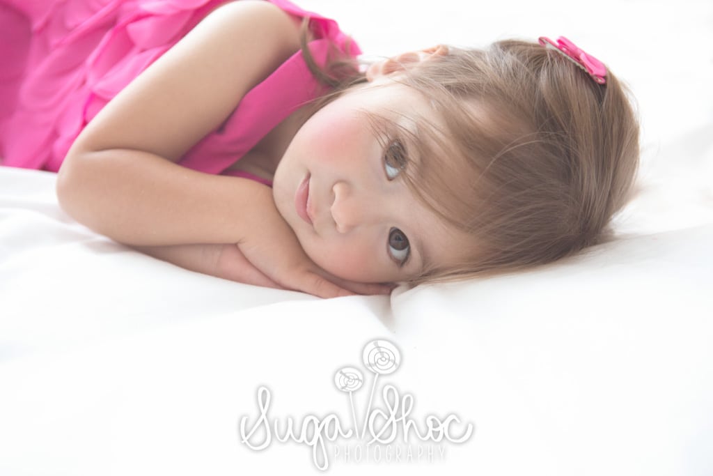 SugaShoc_Photography_Children_Photographer_Bucks County_Doylestown_PA_girl_posed_on_bed_pink_dress
