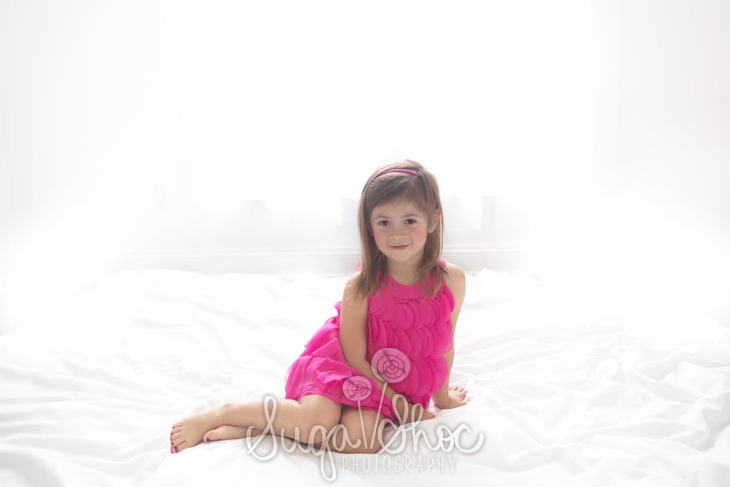 SugaShoc_Photography_Children_Photographer_Bucks County_Doylestown_PA_girl_posed_on_bed_pink_dress