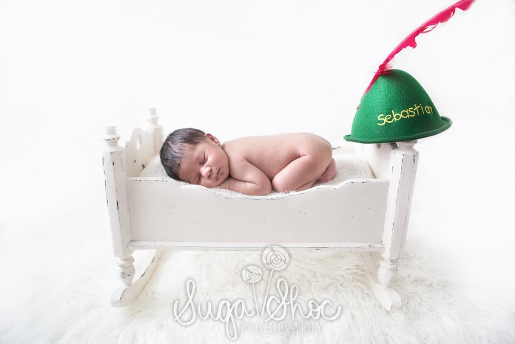 SugaShoc_Photography_Newborn_Photographer_Bucks County_Doylestown_PA_newborn_on_newborn_bed_prop_with_peter_pan_hat_from_disney