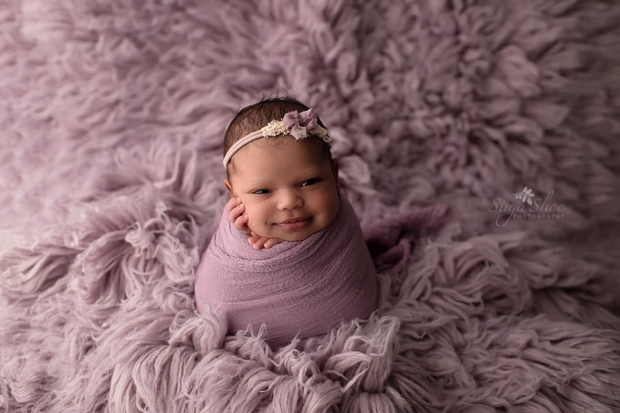 SugaShoc Photography Newborn Photographer Bucks County PA Doylestown PA smiling newborn potato sack pose on flokati