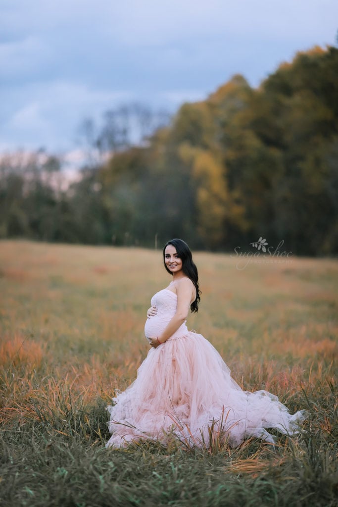 SugaShoc Photography Maternity Photographer Bucks County PA Doylestown PA Tyler State Park Maternity Session standing in field woman wearing pink tulle maternity dress hands on belly