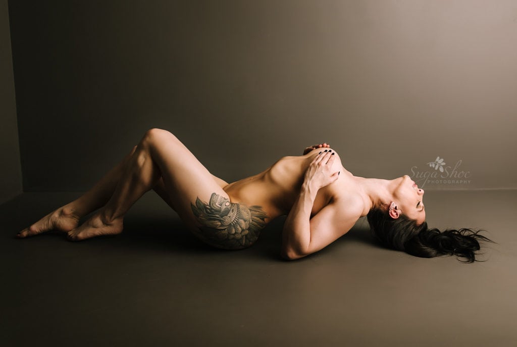 SugaShoc Photography Doylestown Boudoir Photographer PA Fitness Boudoir Session boudoir pose laying on floor naked with hands on breasts and head and back arched