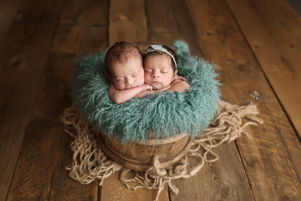 SugaShoc Photography Newborn Photography Bucks County PA Doylestown PA Newborn Twin Photographer baby twins sleeping in wooden bucket with teal sheepskin girl wearing light blue floral headband