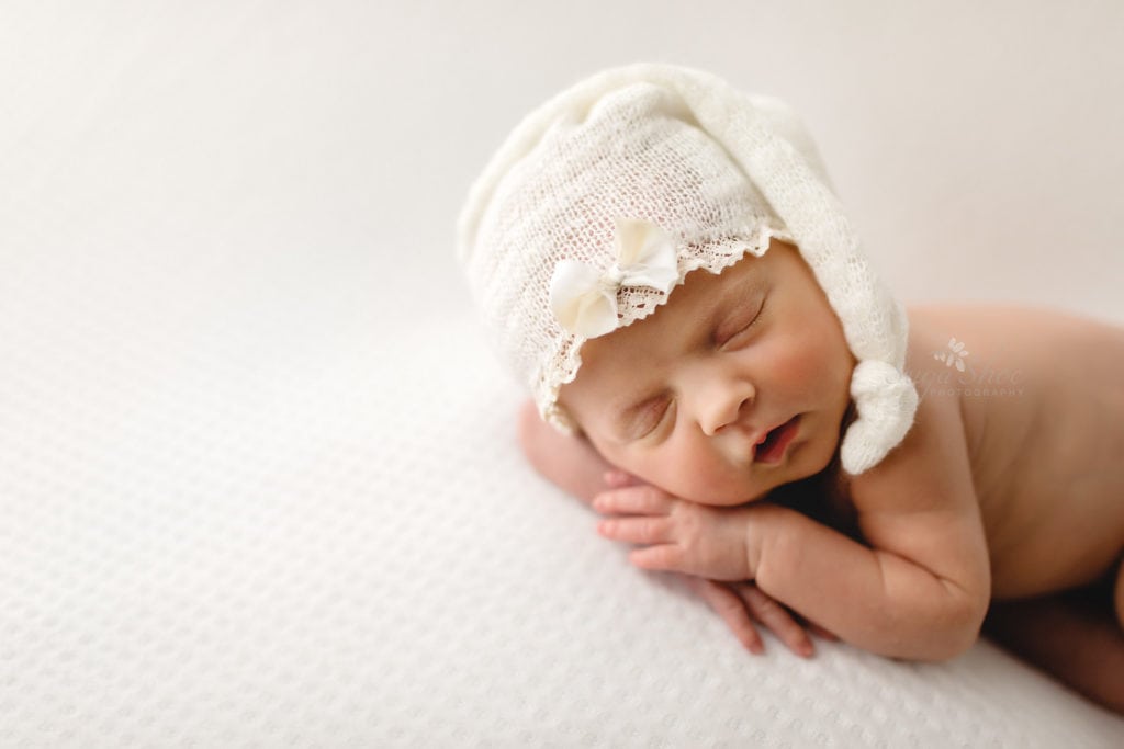 SugaShoc Photography Newborn Photography Bucks County PA Doylestown PA Newborn Photographer Rainbow Newborn Session baby sleeping on white blanket wearing white knit cap