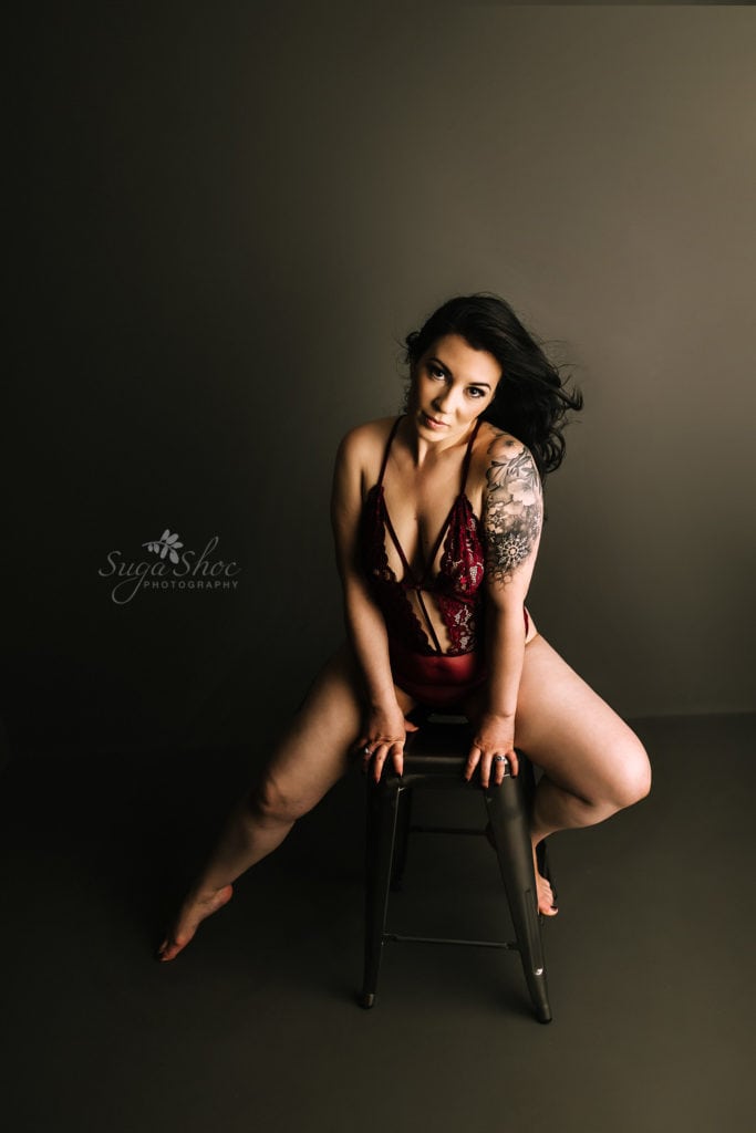 SugaShoc Photography Birthday Boudoir pose sitting on stool wearing red lace teddy