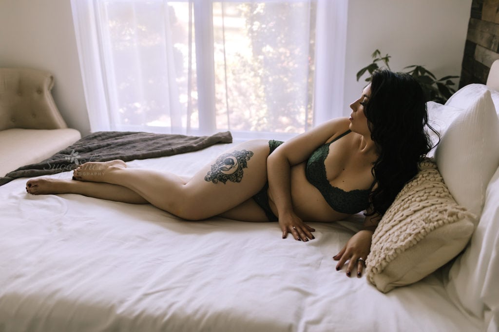 SugaShoc Photography Birthday Boudoir pose laying on side on bed wearing green bra and panty