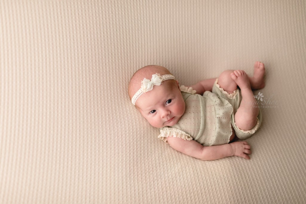 Doylestown Newborn Photographer baby girl looking at camera on back