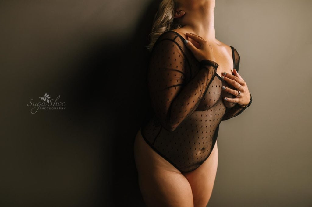 Anniversary Boudoir Sugashoc Photography wearing black lace bodysuit with hands on breast and collar bone close-up