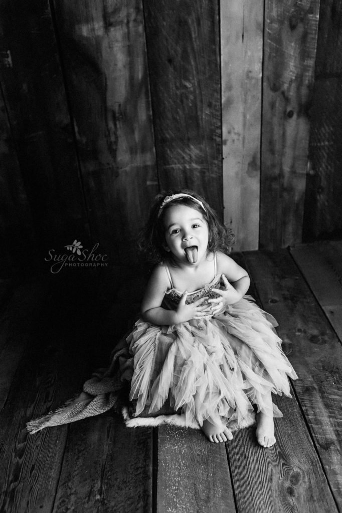 Sugashoc Photography Doylestown Children Photographer girl in gray tulle dress sticking out tongue in black-and-white