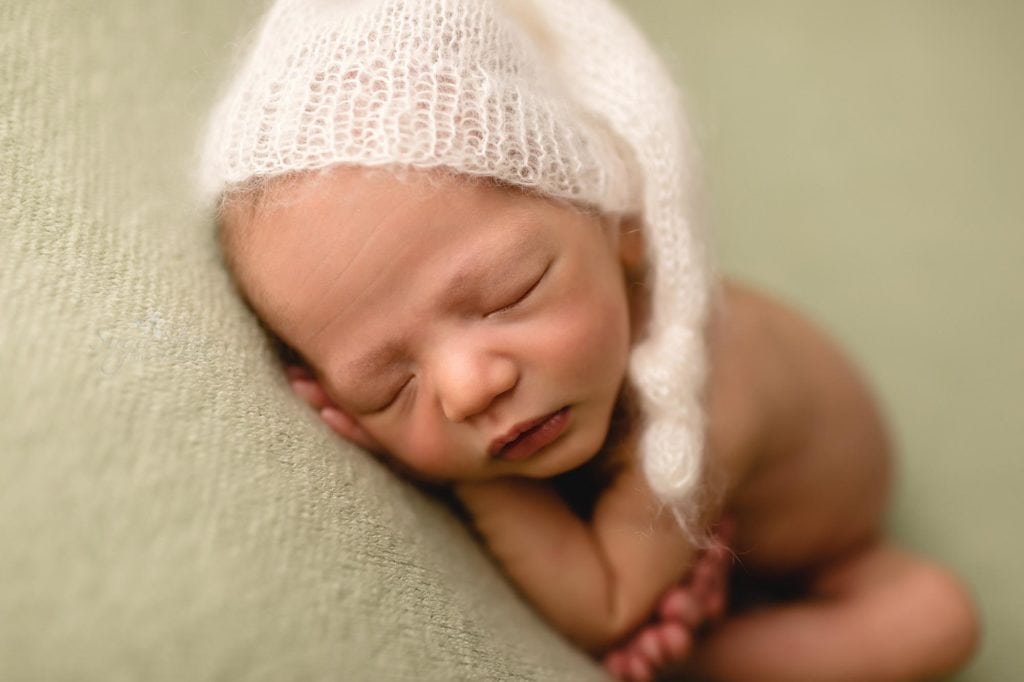 Fur Baby Newborn Session Sugashoc Photography baby boy sleeping on gray blanket with white knit hat close-ip