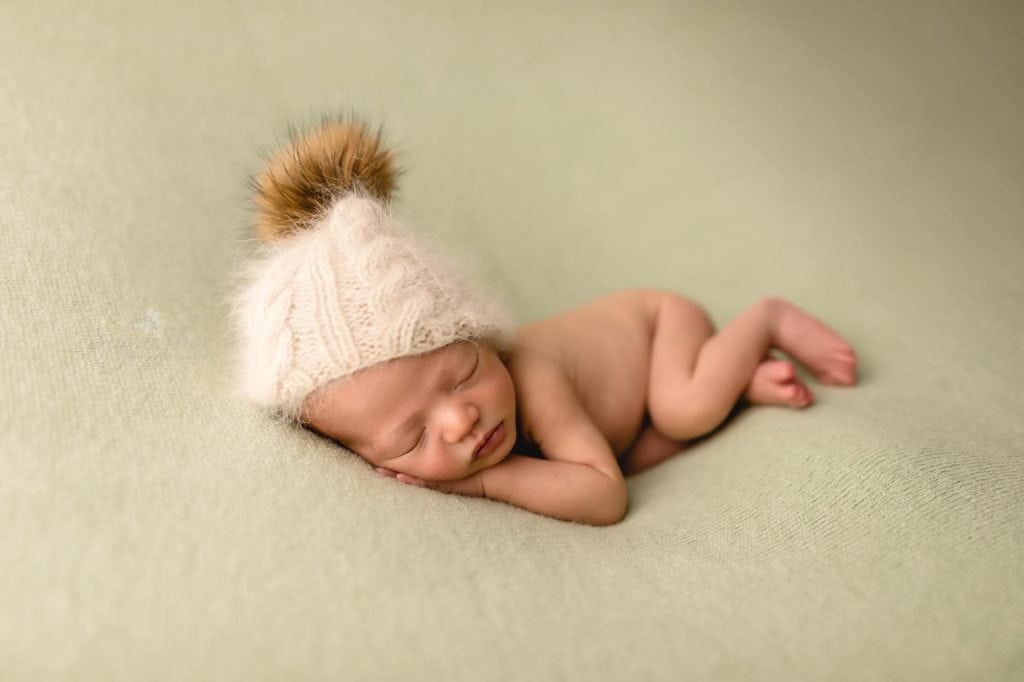 Fur Baby Newborn Session Sugashoc Photography baby boy sleeping on gray blanket with white knit hat with pom pom