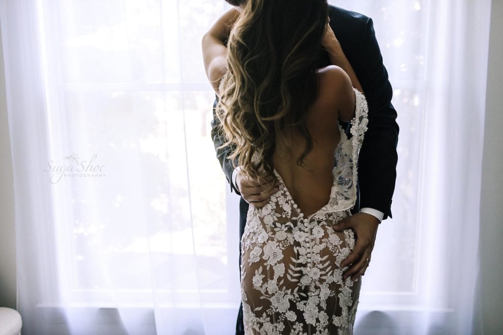 Philadelphia Couples Boudoir Photographer man in suit kissing woman in white lace dress hand on booty