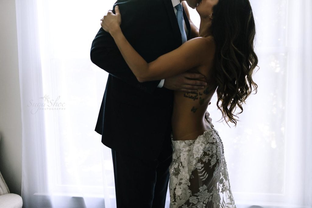 Philadelphia Couples Boudoir Photographer man in suit kissing woman wearing white lace dress