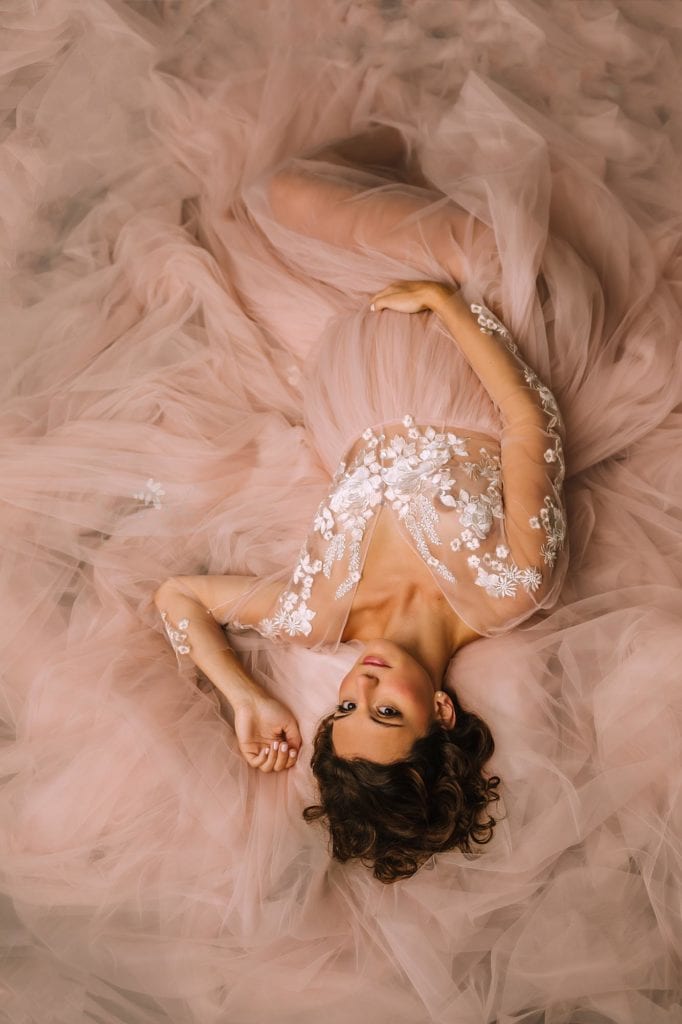Philadelphia Maternity Boudoir Photographer SugaShoc Photography pregnant woman wearing pink tulle dress laying