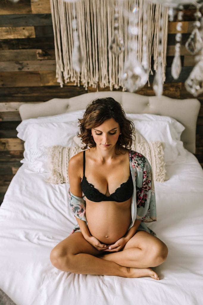 Philadelphia Maternity Boudoir Photographer SugaShoc Photography pregnant woman wearing black bra sitting on bed