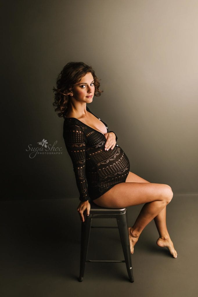 Philadelphia Maternity Boudoir Photographer SugaShoc Photography pregnant woman wearing black body suit sitting on stool