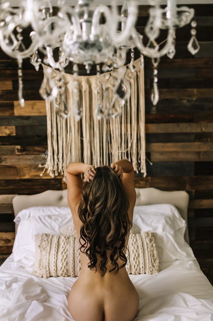 Bridal Boudoir - booty shot with hair flowing down, kneeling on bed facing pallet wall