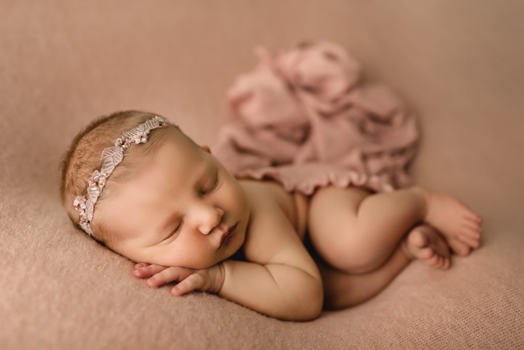 newborn photography doylestown pa, baby girl with headband asleep on pink material