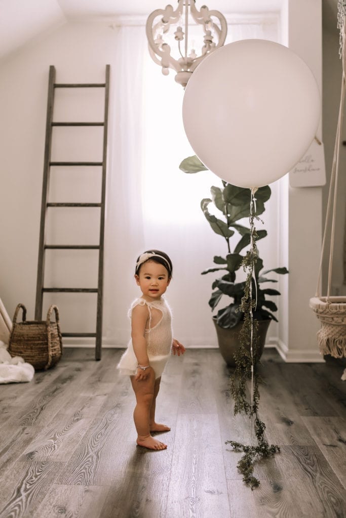 lifestyle baby photography, baby in neutral room with balloon