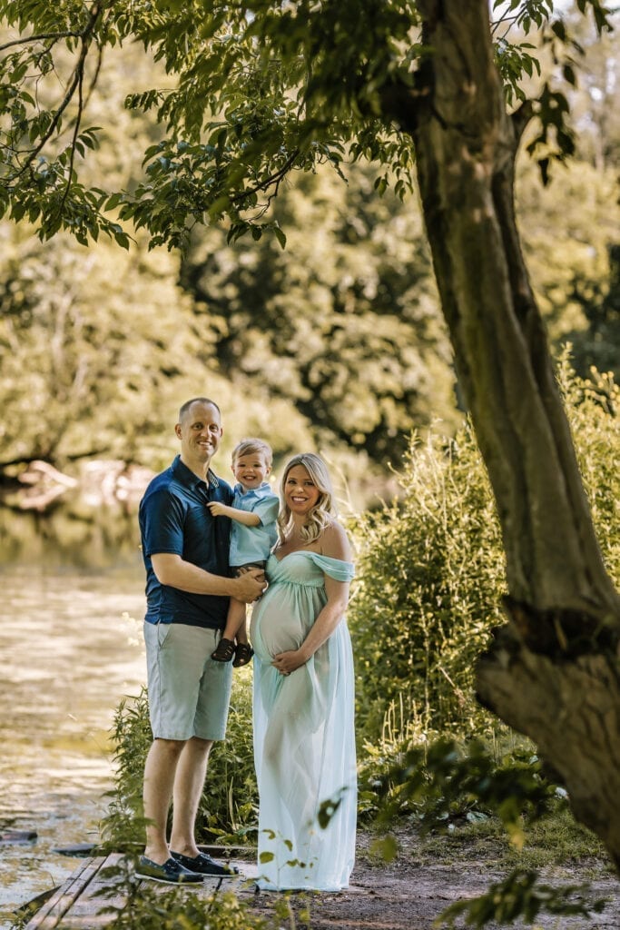 maternity photography outdoor session, pregnant mom with family standing next to tree