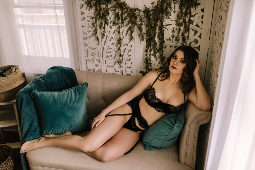 Woman on couch wearing black lace intimate wear, romantic boudoir photos