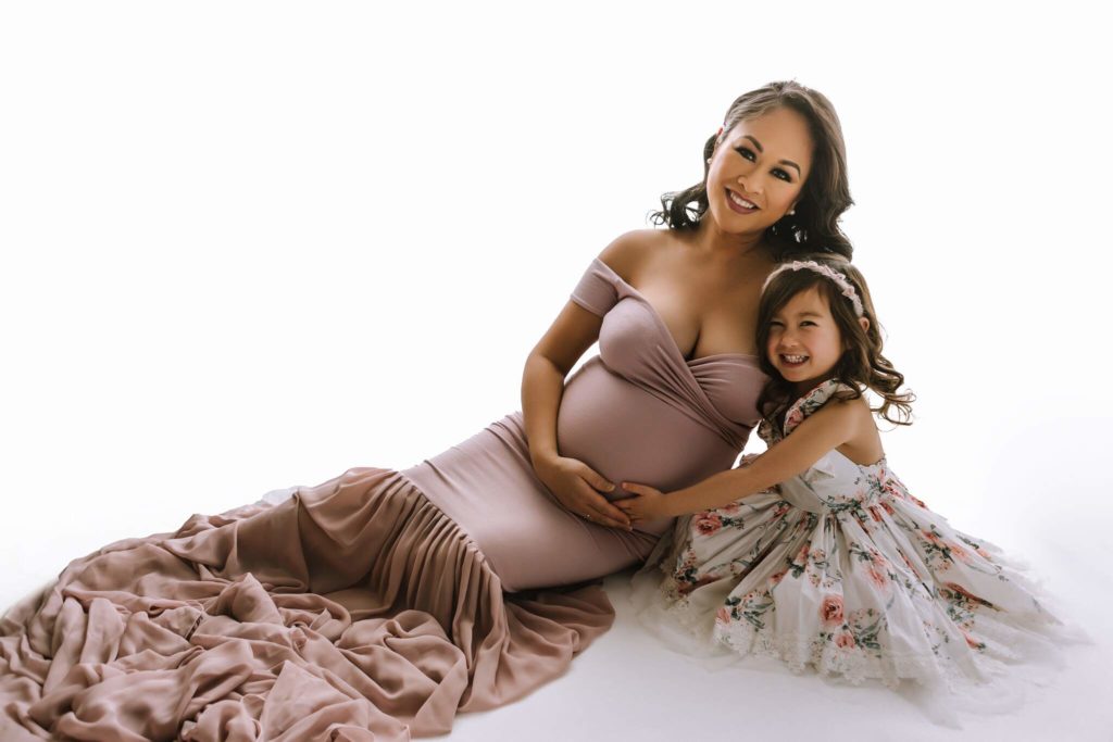 Mother and daughter maternity photo shoot in elegant gowns.