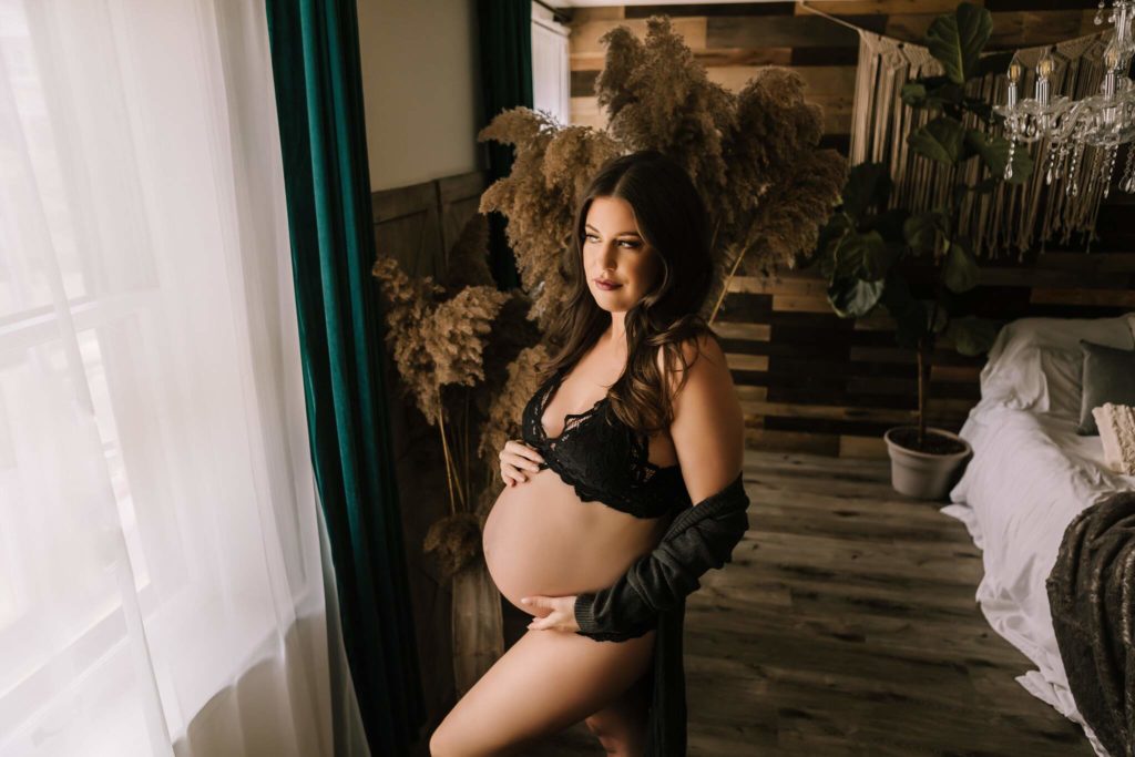 In studio boudoir maternity in Pennsylvania with black lingerie.