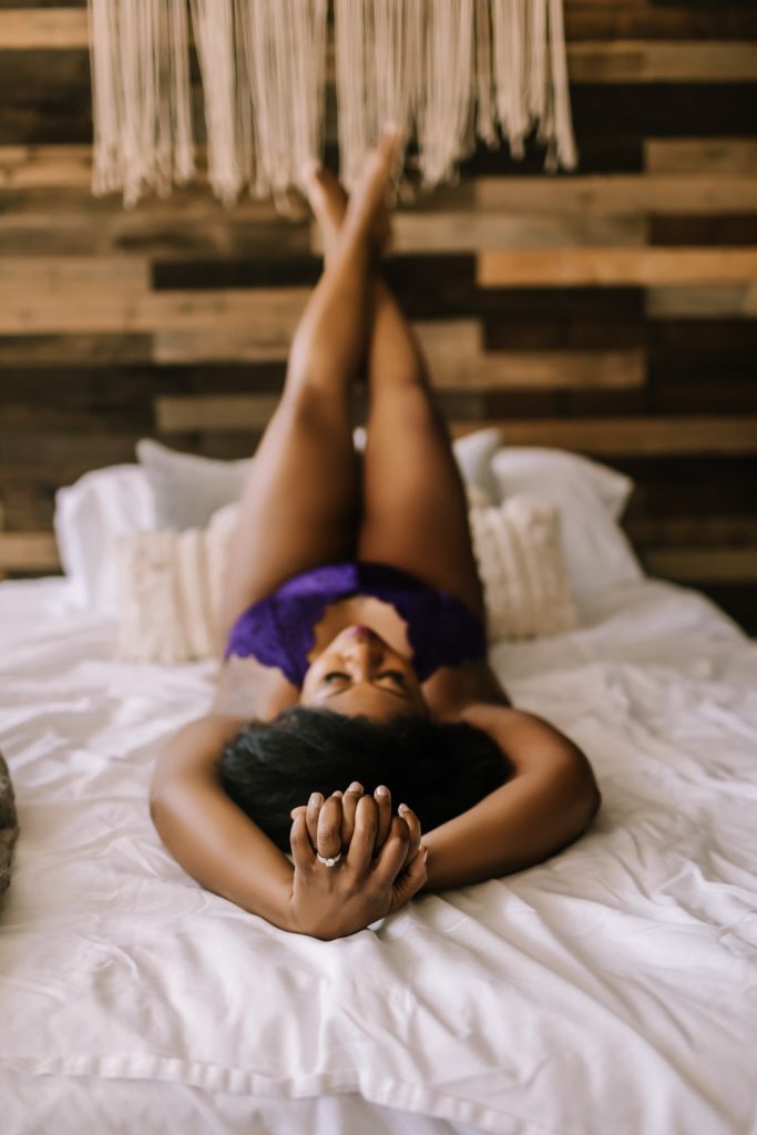 In studio classic beautiful black woman boudoir on bed.