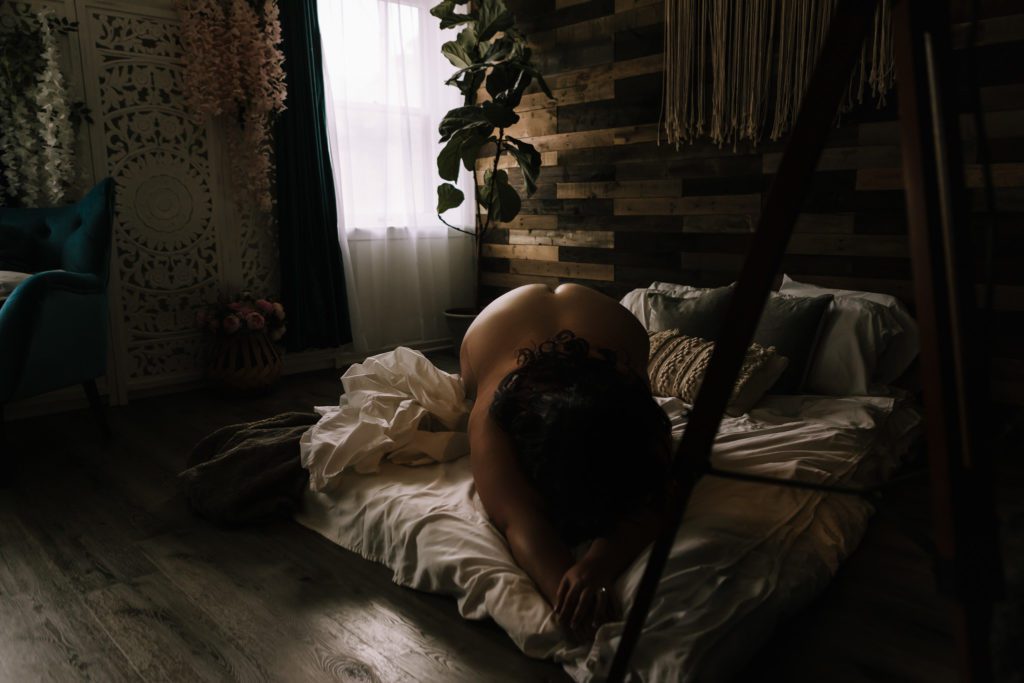 Nude in studio boudoir photoshoot.